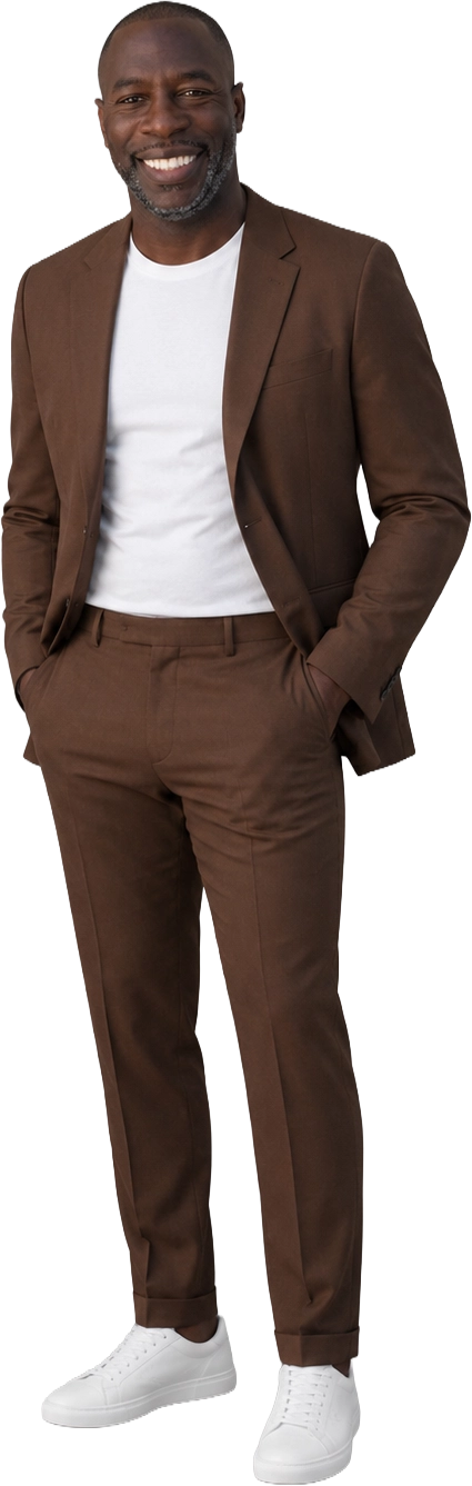 Cassis Sanogo debout en costume marron, t-shirt blanc et baskets blanches